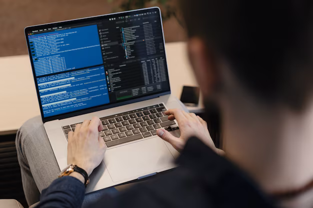 Man writing code on laptop, rear view